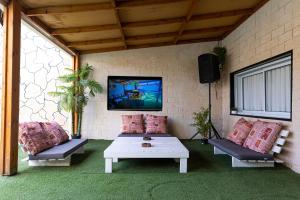 a patio with two couches and a table and a tv at פאטה מורגנה אואזיס - בית נופש פרטי in Beer Sheva