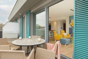 patio ze stołem, krzesłami i tablicą. w obiekcie Sea&Sky View Apartment Par La Mer w mieście Niechorze
