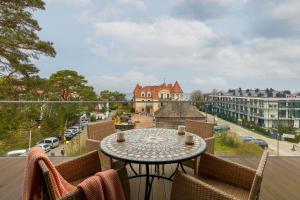 stół na balkonie z widokiem na ulicę w obiekcie Sea&Sky View Apartment Par La Mer w mieście Niechorze