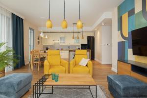 salon z żółtymi meblami i kuchnią w obiekcie Sea&Sky View Apartment Par La Mer w mieście Niechorze