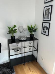 a black shelf with wine glasses and plants on it at Köln City Stillvolle Apartment in Cologne