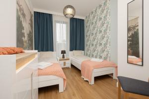 sypialnia z dwoma łóżkami i lustrem w obiekcie Sea&Sky View Apartment Par La Mer w mieście Niechorze