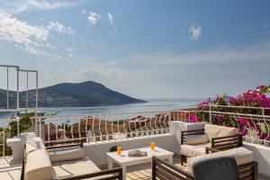 a balcony with chairs and tables and a view of the ocean at Korsan Apartment No.16 in Kaş