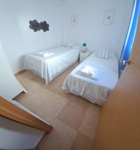 een kleine kamer met 2 bedden en een trap bij Geranio Chipionahome in Chipiona