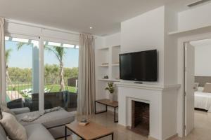 Villa Girasol في بينالوب-كاساس فايخاس: غرفة معيشة مع موقد وتلفزيون بشاشة مسطحة