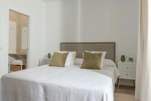 1 dormitorio blanco con 1 cama blanca grande y 2 almohadas en Villa Girasol, en Benalup-Casas Viejas