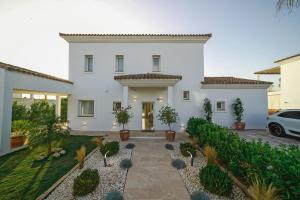 una casa blanca con macetas en un patio en Villa Girasol, en Benalup-Casas Viejas
