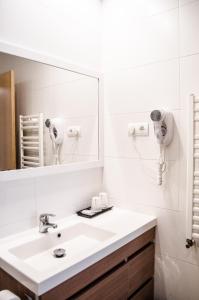 y baño con lavabo blanco y espejo. en Hotel Jaqués en Jaca