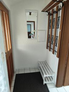 um corredor com um banco de madeira e um espelho em Ferienwohnung Lay em Hirschaid