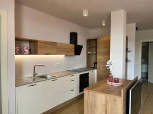a kitchen with white cabinets and a sink at Favolabella The Loft in Bardolino