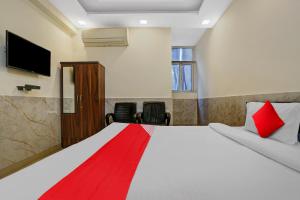 1 dormitorio con 1 cama grande con manta roja en Flagship Welcome Hotel Near Dlf Avenue Saket, en Nueva Delhi