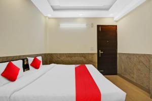 1 dormitorio con 1 cama con almohadas rojas y puerta en Flagship Welcome Hotel Near Dlf Avenue Saket, en Nueva Delhi