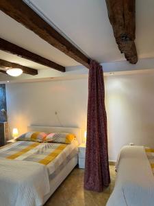 a bedroom with two beds and a ceiling with beams at Apartments Bernarda in Skrbčići