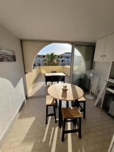 un balcon avec une table et des chaises dans une pièce dans l'établissement Grand T2 proche de la mer, à Sète