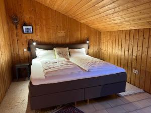 a bed in a room with a wooden wall at Grimmersberg in Oberkirch