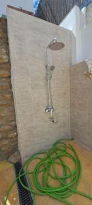 a shower with a hose hooked up to a wall at Geranio Chipionahome in Chipiona