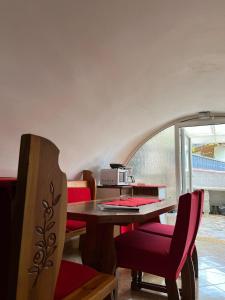 cocina con mesa de madera y sillas rojas en Apartments Bernarda en Skrbčići