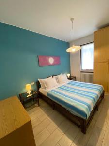 een slaapkamer met een groot bed met een blauwe muur bij Residence al Lago - Casa Lucia in Paratico