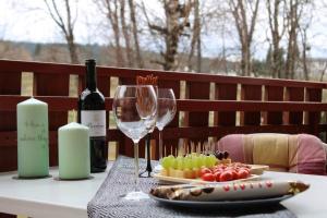 a table with a bottle of wine and wine glasses at Ferienresort mit Pool am Schluchsee in Schluchsee
