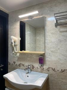 a bathroom with a sink and a mirror at Hotel Sonata in Batumi
