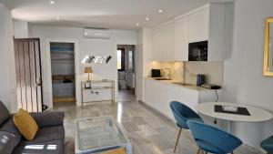 a living room with a couch and a table and a kitchen at Aldea Blanca Cute in Marbella