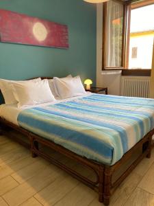 een bed in een slaapkamer met een blauwe muur bij Residence al Lago - Casa Lucia in Paratico