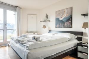 a bedroom with three beds and a large window at Apartment Alpenrose 2.5 mit Mitbenutzung SPA & Wellness - GRIWA RENT AG in Beatenberg