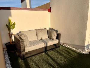 a wicker chair with pillows sitting on a patio at Parque Botanico Resort & Country Club in Estepona