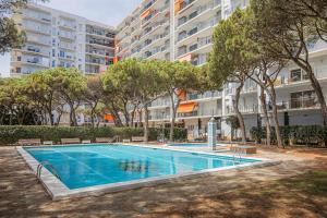 a swimming pool in front of a large apartment building at Apartamento Condal in Blanes