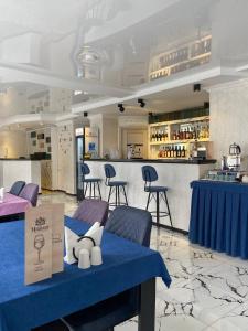 um restaurante com uma mesa azul com cadeiras e um bar em Hotel Sonata em Batumi
