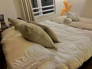 Cama blanca con almohadas y ventana en Departamento Central Ejecutivo- Apart Hotel, en Calama