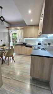 a large kitchen with a counter and a table at Modern Garden View Apt in Voula, Athens - Luxe in Athens