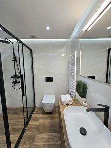 a bathroom with a tub and a toilet and a sink at Modern Garden View Apt in Voula, Athens - Luxe in Athens
