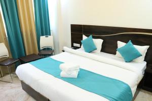 a bedroom with a large bed with blue and white pillows at Hotel Hidden Delight Rishikesh in Rishīkesh