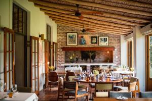 a restaurant with tables and chairs and a brick wall at Stanford Valley Country Lodge in Stanford