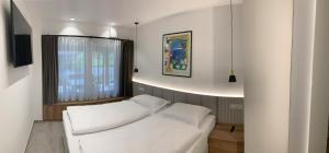 ein weißes Bett in einem Zimmer mit Fenster in der Unterkunft Žigon Bed & Breakfast in Logatec