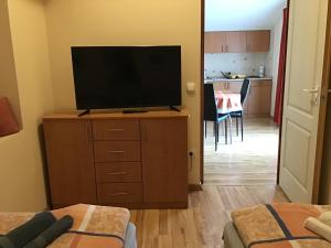 a living room with a flat screen tv on a dresser at Drávecz Apartman in Balatonlelle
