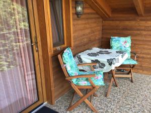 einen Tisch und zwei Stühle auf der Veranda einer Hütte in der Unterkunft Drávecz Apartman in Balatonlelle