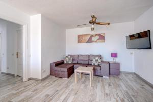 ein Wohnzimmer mit einem Sofa und einem Tisch in der Unterkunft BuenaVista Palmeras in Costa Adeje in Adeje