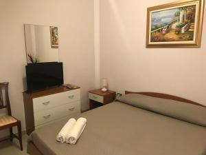 - une petite chambre avec un lit et une télévision dans l'établissement villa mediterranea, à Realmonte