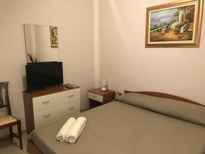 una piccola camera con letto e televisore di villa mediterranea a Realmonte