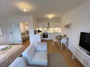 ein Wohnzimmer mit einem Sofa und einer Küche in der Unterkunft Smultron Apartment Altstadt Wismar in Wismar