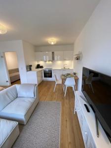 a living room with a white couch and a kitchen at Smultron Apartment Altstadt Wismar in Wismar