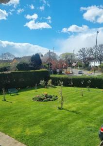 a green park with a bench and flowers in the grass at Spacious self contained flat in superb location in Lymington