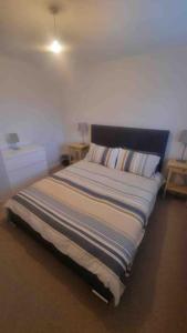 uma cama num quarto com duas mesas de cabeceira em Spacious self contained flat in superb location em Lymington