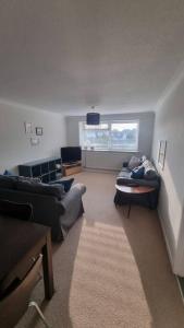 a living room with two couches and a window at Spacious self contained flat in superb location in Lymington