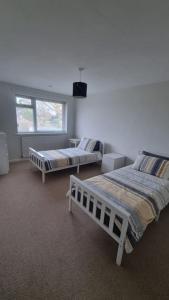 1 dormitorio con 2 camas y ventana en Spacious self contained flat in superb location, en Lymington