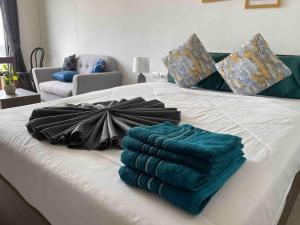 a white bed with towels and an umbrella on it at The Base Central - Luxury Resort-Style Comfort in Ban Rangeng +74 photos