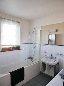 a bathroom with a bath tub and a sink at Close to beaches and town, off street parking in Kent