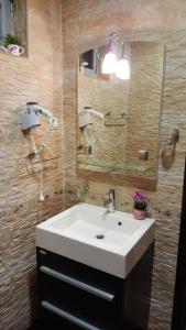 a bathroom with a white sink and a mirror at Apartments Rino Lux in Sveti Stefan